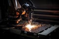 welding robot, with its welding torch in motion, joining two metal plates together