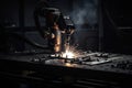 welding robot, with its welding torch in motion, joining two metal plates together