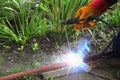 Welding work on the street. Welder cooks metall parts on the ground