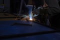 Welding work. A welder in a workshop welds a steel piece Royalty Free Stock Photo