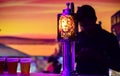 Lion lager backlit logo on a liquor pub table and 3 beer cups. Silhouetted bartender in the