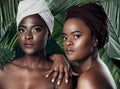 Well always be proud of our heritage. Studio portrait of two beautiful young women posing in front of palm leaves Royalty Free Stock Photo