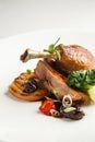 Well-browned and crisp duck confit with roast fennel, citrus fruit and prune sauce. Roasted Duck leg. White dish Royalty Free Stock Photo