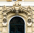 Well decorated exterior door with three faces and floral elements