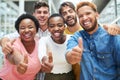 Well done from all of us. Portrait of a group of young businesspeople showing thumbs in a modern office. Royalty Free Stock Photo