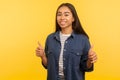 Well done, awesome result! Portrait of happy girl in denim shirt showing thumbs up, gesturing like and smiling