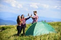 Well done. Camping gear. Camping tent. Good job. Teamwork concept. Hiking activity. Friends set up tent on top mountain