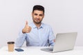 Well done, good job! Happy elegant businessman sitting office workplace, showing thumbs up, like gesture Royalty Free Stock Photo