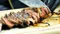 Well-done rilled marinated beef flank steak on wooden board