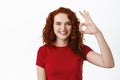 Well done. Smiling confident teen ginger girl showing OK sign, approve and agree, praise excellent choice and looking