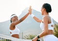 Well done to both of us. two sporty young women giving each other a high five while playing tennis together on a court. Royalty Free Stock Photo