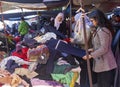 Well-dressed black-haired Tunisian young lady checks the textile offer on the clothes grab table in the market