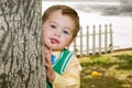 Well Dressed Boy Peeks Around A Tree