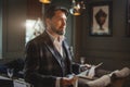 Well-dressed business man reading newspaper in indoor restaurant Royalty Free Stock Photo