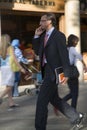 Well-dressed businessman speaking on cell phone on Passeig de GrÃ¯Â¿Â½cia in the Eixample district, busy street in Barcelona, Spain,