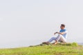 Well dressed  fashionable man stands in nature looking over a cliff at the large lake and mountain line while wearing boat shoes Royalty Free Stock Photo