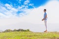 Well dressed  fashionable man stands in nature looking over a cliff at the large lake and mountain line while wearing boat shoes Royalty Free Stock Photo