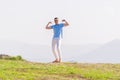 Well dressed  fashionable man stands in nature looking over a cliff at the large lake and mountain line while wearing boat shoes Royalty Free Stock Photo