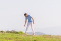 Well dressed  fashionable man stands in nature looking over a cliff at the large lake and mountain line while wearing boat shoes Royalty Free Stock Photo