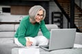 Well-dressed gray haired woman on retirement managing family budget at home Royalty Free Stock Photo