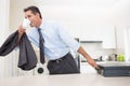 Well dressed man drinking coffee while holding briefcase in kitchen Royalty Free Stock Photo