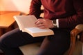 Well dressed man reading in home library, sitting in old chair Royalty Free Stock Photo