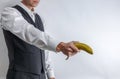 Well dressed man in suit vest holding a banana like a gun Royalty Free Stock Photo