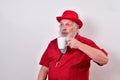 Well dressed man wearing a red derby hat, red shirt and large bolo tie is enjoying a fine mug of coffee Royalty Free Stock Photo