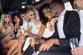 Well dressed people drinking champagne in a limousine Royalty Free Stock Photo