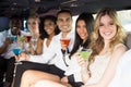 Well dressed people drinking cocktails in a limousine Royalty Free Stock Photo