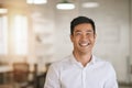 Smiling Asian businessman standing in a bright modern office