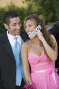 Well-dressed young couple using cell phone