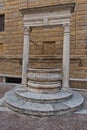 Well in front of a church wall at small square in Pienza , Siena province, Tuscany Royalty Free Stock Photo