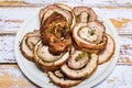 Well grilled porchetta sliced into rounds in a dish and ready to serve