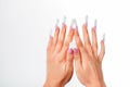 Well-groomed female hands with elegant french manicure on a white background. Long nails. Beauty salon. Photo for the