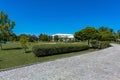 Well-groomed green area of country estate with cobbled pavement leading to mansion