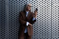 well-groomed healthy slender gray-haired mature business lady dressed in a stylish brown jacket uses a smartphone to