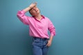 well-groomed little tired young blond caucasian woman model with ponytail hairstyle put on a pink shirt and jeans Royalty Free Stock Photo