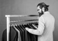 well groomed man in wedding formalwear has beard choose jacket in wardrobe, designer