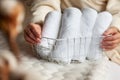 Well groomed woman hands is holding metal mesh storage basket with pile of rolled up white towels Royalty Free Stock Photo