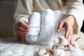 Well groomed woman hands is holding metal mesh storage basket with pile of rolled up white towels Royalty Free Stock Photo