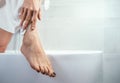 Well groomed woman`s feet on bathtub edge