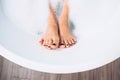 Well groomed woman`s legs in bath foam close up image Royalty Free Stock Photo