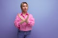 well-groomed young blond caucasian woman model with ponytail hairstyle put on a pink shirt and jeans crossed her fingers Royalty Free Stock Photo