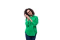 well-groomed young female marketing employee with black hair dressed in a green shirt on a white background with copy