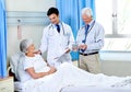 Well have you better in no time. two doctors attending a senior patient who is in a hospital bed. Royalty Free Stock Photo