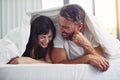 Well hello there. a cheerful young couple crawling out of bed while having a laugh together during morning hours. Royalty Free Stock Photo