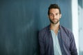 Well, hello there. Portrait of a confident young man leaning against a blackboard. Royalty Free Stock Photo