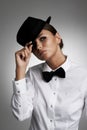 Well, hello there. A young woman in a shirt and bow tie tipping her hat to you. Royalty Free Stock Photo