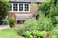A well kept back yard or garden with lawn, flowers and seating area
